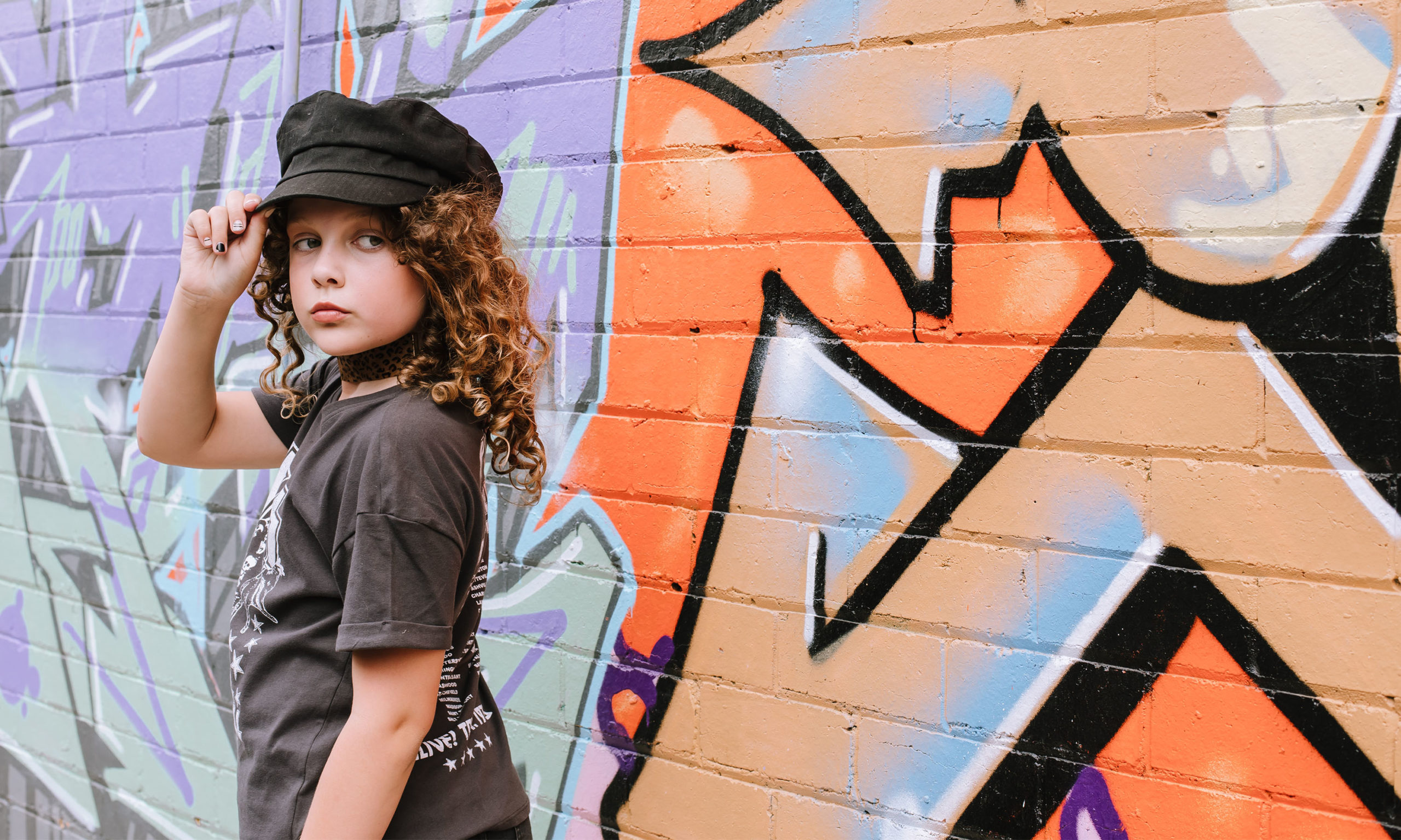 girl posing beside graffiti walls_kid models in australia