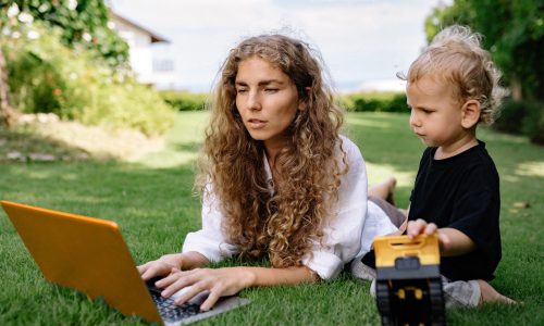 mum researching using laptop in the garden with a toddler